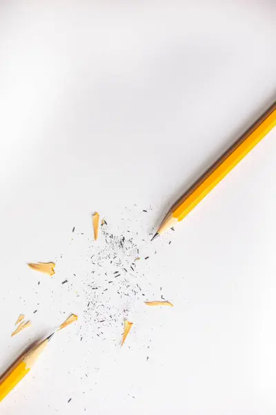 Stock image pencils and pencil shavings against white paper