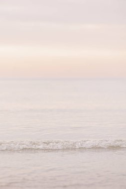 Gün batımında Wingaersheek Sahili 'nde kıyıya doğru hafif bir dalga yaklaşıyor.