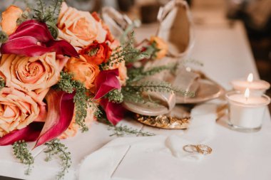 Alyansları, mumları ve ayakkabıları olan bir buket