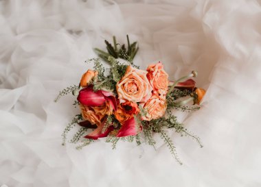 Şeftali gülleri ve mor zambaklı gelin buketi.