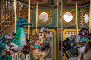 Ornate carousel with detailed horse and seahorse figures. clipart