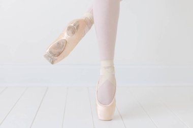 Beyaz stüdyoda balerinin ayaklarını dikleştir.