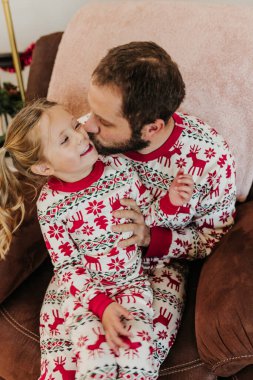 Babam, kızı sandalyeye otururken kollarına aldı.