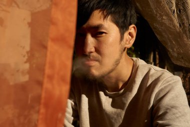 Sigara içen Asyalı bir adamın portresi