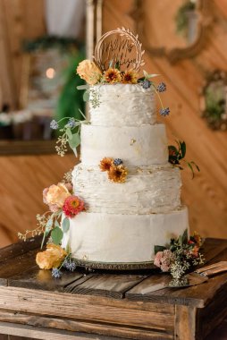 Kırsal düğün pastası, desenli krema ve sonbahar çiçekleri.