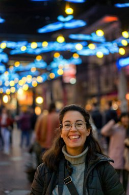 Eindhoven şehir merkezinde genç bir kadın gece kameraya gülüyor.