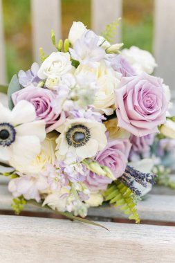 Bir buket lavanta gülleri, beyaz şakayıklar ve bir bankta yeşillik.