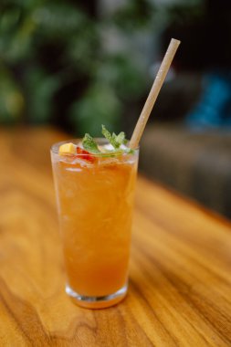 Portakal kokteyli ve ahşap bir masada bir nane şekeri..