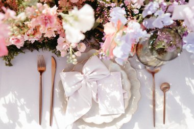 canlı çiçekler ve renkli menüler düğün masasında.