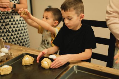 Genç çocuklar geleneksel İtalyan Paskalya Yumurta Sepetleri hazırlıyorlar.