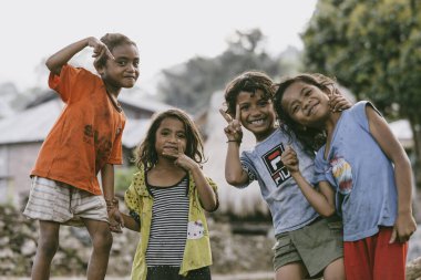 Bir grup çocuk Endonezya köyünde poz veriyor.
