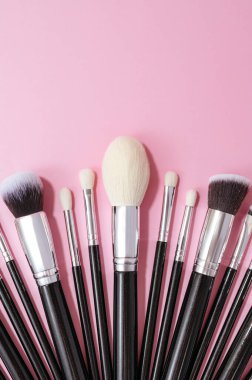 Renkli arkaplanda makyaj fırçaları.