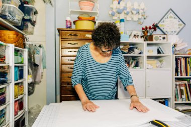 Dikiş odasında kumaşı ölçen yorgan.