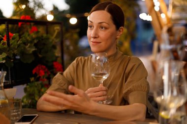 Restoranda elinde cam olan kadın.