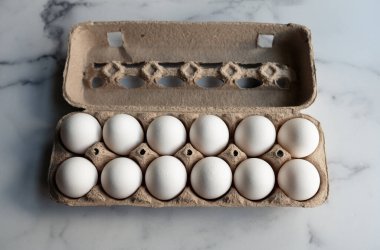 Mermer tezgahın üzerinde bir kutu beyaz yumurta..