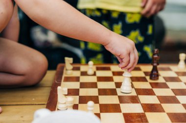 Çocuk eli bir oyun sırasında satranç taşını oynatıyor.