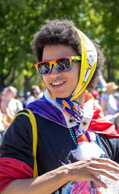 Gökkuşağı güneş gözlüğü ve eşarp takan kişi