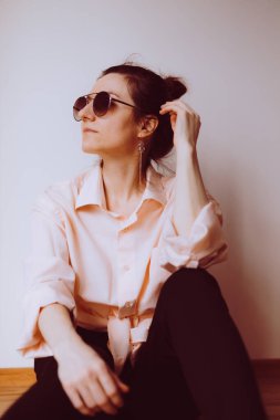 Minimalist tarzda modern bir kadın evde oturuyor.