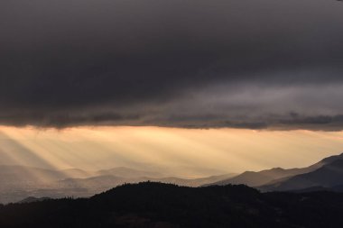 Oaxaca, Meksika dağlarının üzerinde karanlık gökyüzü ile gün batımının görüntüsü 