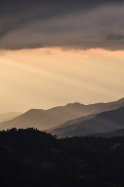 Oaxaca, Meksika 'daki dağların ardından gün batımının ışıklarını izliyoruz. 
