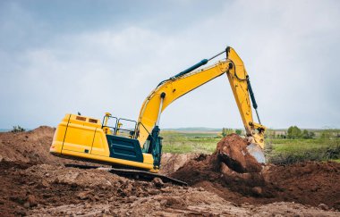 Kazıcı açık alanda gevşek toprağı hareket ettiriyor.