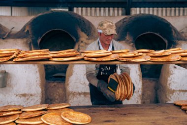 Bir adam fırında pizza yapıyor.