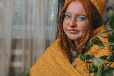 Gündelik zarafet: Evcil Ambiyansı kucaklayan, ekose elbiseli kızıl saçlı kız