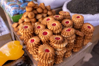 Masanın üzerinde kırmızı merkezli bir kurabiye yığını var.