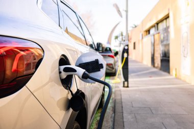 Halka açık şarj istasyonunda elektrikli bir araba gösteriliyor.