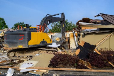 A large excavator machine tears down a defunct building. clipart