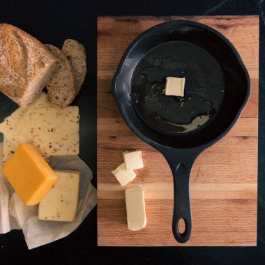 Tahtadaki tavanın yanında ekmek, peynir ve tereyağı.