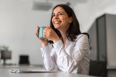 Cheerful and smiling young woman holding a cup of coffee clipart