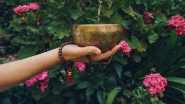 Tanınmayan kadın Tibet şarkı kasesi çalıyor.