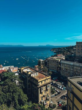 Arka planda mavi bir okyanus olan Napoli manzarası