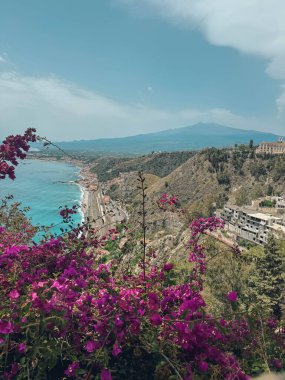 Arka planda etna volkanı olan güzel bir sahil manzarası.