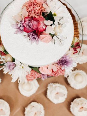 Çiçekli ve uyumlu kekleri olan zarif bir pasta, beyaz.