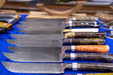 Farklı renk ve tasarımlara sahip bir sıra bıçak görüntülenir