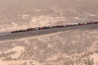 Uzak bir çöl ortamında paralel yük trenleri geniş görüşlü.