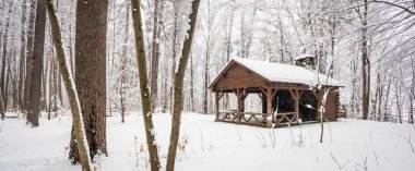 Picnic cabin in winter snowstorm at Dutton Pines State Park Verm clipart