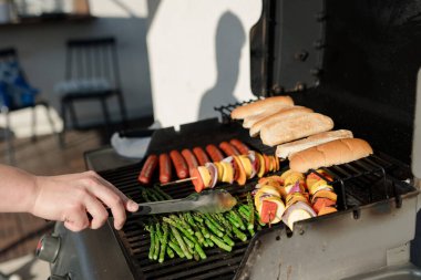 Kızarmış kuşkonmaz, sosisli sandviç, şiş ve çörekler.