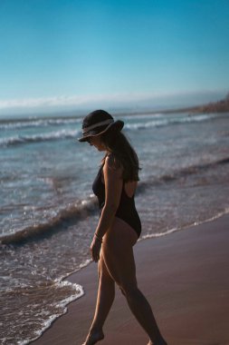 Sahilde dikilmiş manzaraya bakan bir kadın..