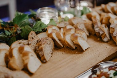 Dilimlenmiş ekmek ve mayalı örgü bir açık büfe masasında.