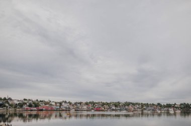 A yellow dory paddling in the Lunenburg harbour clipart