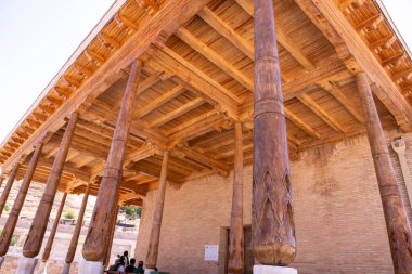 The wooden pillars are part of a building with a brick exterior clipart