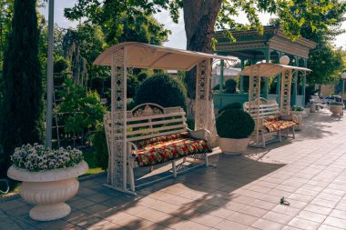 A park with two benches and a gazebo clipart