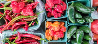 Marketteki sepetlerde çeşitli renkte kırmızı biberler.