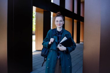 Sırt çantası ve kitaplarıyla gözlüklü öğrenci kız.