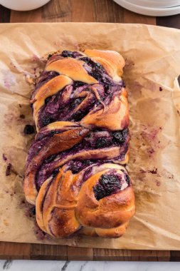 Yaban mersini krem peynirli babka parşömen kağıdında, taze pişmiş.