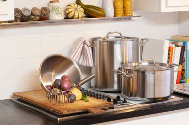 Mutfak sahnesi, tencere, patates ve mutfak aletleri.