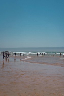 Portekiz 'in batısında dalgalar, kayalıklar ve insanlar var..